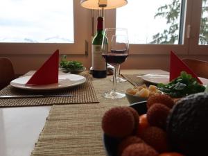 a table with a plate of food and a glass of wine at Apartment be und mee by Interhome in Rigi Kaltbad