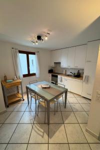 a kitchen with a table and a kitchen with white cabinets at Apartment Walserwohnung by Interhome in Bosco Gurin