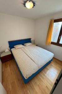 a bedroom with a bed with a blue headboard at Apartment Walserwohnung by Interhome in Bosco Gurin +7 photos