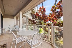 a patio with a table and chairs on a balcony at Grand Champions 033 in Wailea