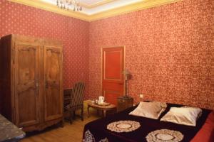 a bedroom with a bed and a cabinet and a table at Lit en Loire in Saint-Cyr-sur-Loire
