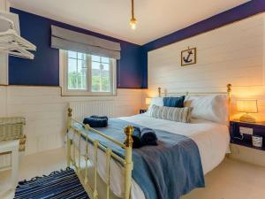 a bedroom with a bed with blue walls and a window at 6 Bed in Rye- oc-89037 in Camber