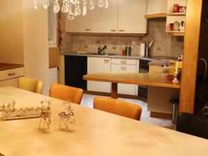 a kitchen with white cabinets and a table with chairs at Apartment Karotte by Interhome in Trub