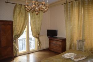 a bedroom with a bed and a chandelier and a window at Lit en Loire in Saint-Cyr-sur-Loire