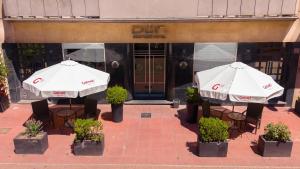 two white umbrellas in front of a building at DON Boutique Hotel Montevideo in Montevideo