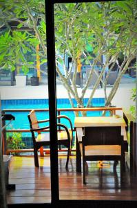 a table and a bench and a tree outside a window at Family House Zen Boutique Resort in Pai