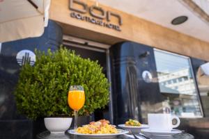 a table with plates of food and a glass of orange juice at DON Boutique Hotel Montevideo in Montevideo