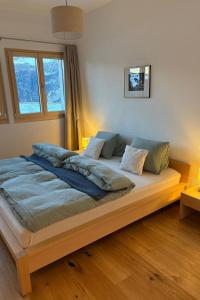 a large bed in a room with two windows at Apartment Poste viglia by Interhome in Lohn