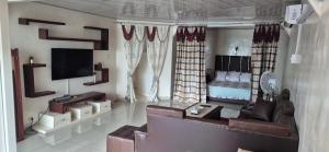 a living room with a couch and a bed at Hôtel Restaurant Le Papillon in Goungouamoué +134 photos