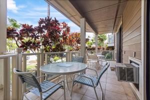 a patio with a table and chairs on a balcony at Grand Champions 033 in Wailea