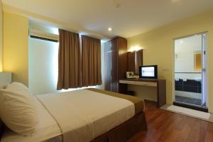 a hotel room with a bed and a television at Seasons View Hotel in Kuantan