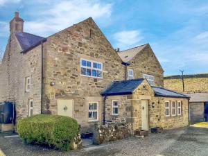 an old stone house with a blue roof at 4 Bed in Hexham oc-90521 in Bardon Mill