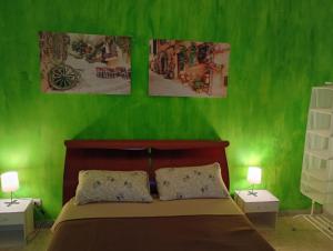 a bedroom with green walls and a bed with two lamps at L'Ancora in Bisceglie