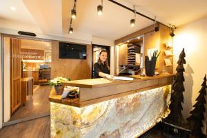 a woman standing behind a counter in a store at Hotel Am Schloss *** Superior in Tübingen