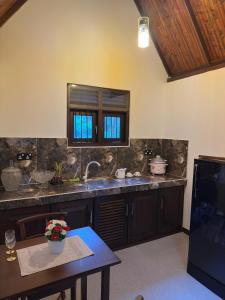 a kitchen with a sink and a table at Sansun Villa in Harumalgoda West