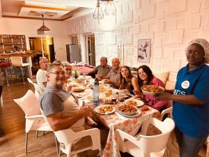 a group of people sitting around a table eating food at Mdf Saloum in Poundiougne