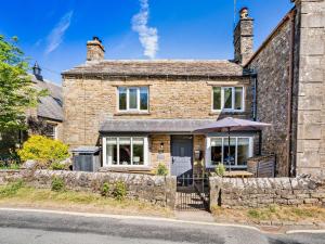 an old stone house with an umbrella in front of it at 3 Bed in Richmond oc-75649 in Muker