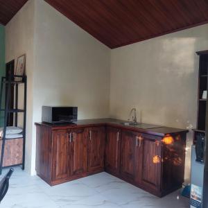 a kitchen with wooden cabinets and a sink at Green Trails Miravalles in Bagaces
