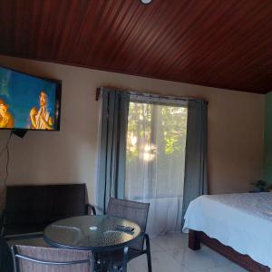 a bedroom with a bed and a table and a window at Green Trails Miravalles in Bagaces +13 photos