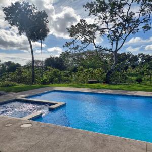 a swimming pool with blue water in a yard at Green Trails Miravalles in Bagaces