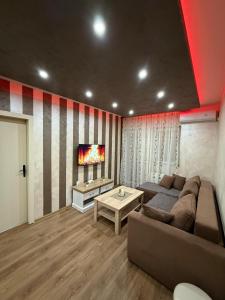 a living room with a couch and a tv at Perisic Apartman Obrenovac, sa parkingom in Obrenovac