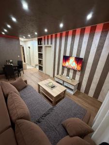 a living room with a couch and a tv at Perisic Apartman Obrenovac, sa parkingom in Obrenovac