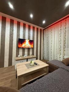 a living room with a fireplace and a tv on a wall at Perisic Apartman Obrenovac, sa parkingom in Obrenovac