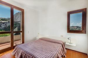 una camera con un letto e una grande finestra di Residence Baia Santa Reparata a Santa Teresa di Gallura