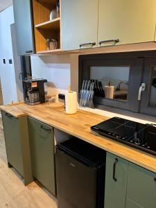a kitchen with a counter with a laptop on it at Tiny Marae in Straja +8 photos