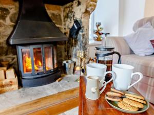 a table with cookies on a plate in front of a fireplace at 3 Bed in Baslow oc-pk917 in Baslow