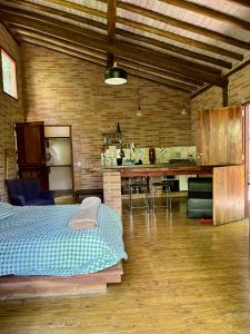 a room with a bed and a kitchen in it at Chalé nas Árvores -Pitayas Agroturismo in Joanópolis