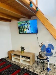 a room with a fan and a tv on a wall at Art studio 1 in El Jadida