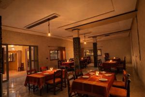a restaurant with wooden tables and chairs with candles on them at Riad Mifis in Rissani +17 photos