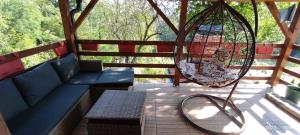 a porch with a swing and a bench and a swingoit at Vikendica Popovic in Doboj +1 photo