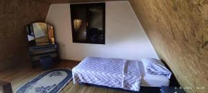 a small bedroom with a bed and a mirror at Vikendica Popovic in Doboj