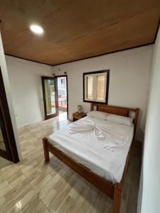 a bedroom with a bed and a wooden floor at Resort Ideal Forest in São Tomé