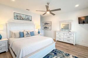a white bedroom with a bed and a ceiling fan at New- Prime Location - Ground Floor Bedroom - Pool in Eastpoint
