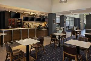 a restaurant with tables and chairs and a bar at Courtyard by Marriott Sacramento Midtown in Sacramento