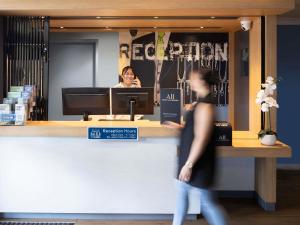 a woman standing in front of a hair salon at ibis Budget Brisbane Airport in Brisbane