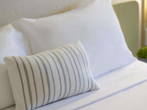 a white pillow sitting on top of a bed at ibis Budget Brisbane Airport in Brisbane