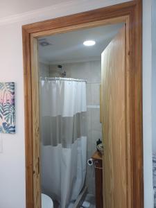 a bathroom with a shower with a white shower curtain at Tomy in Río Grande +14 photos