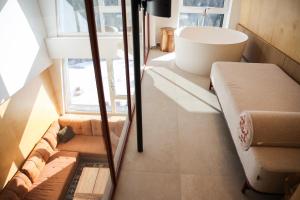 a room with a couch and a window and a tub at A63 Premium apartment located in hotel Vucko-private host in Jahorina +52 photos