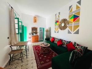 a living room with a green couch and a table at Art studio 1 in El Jadida