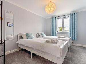 a white bedroom with two beds and a window at 2 Bed in Freshwater oc-94561 in Freshwater