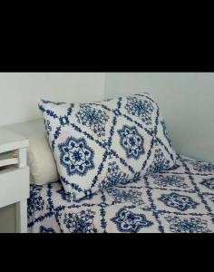 a blue and white pillow sitting on top of a bed at Casa na várzea Quarto 1 in Recife