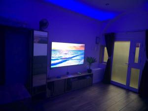 a living room with a large television in a purple room at Studio Groundfloor Apartment in Il-Gżira