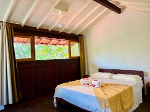 a bedroom with a bed with two stuffed animals on it at Pousada e Restaurante do Paulo in Jijoca de Jericoacoara