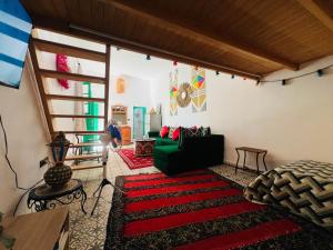 a living room with a green couch and a red rug at Art studio 1 in El Jadida +21 photos