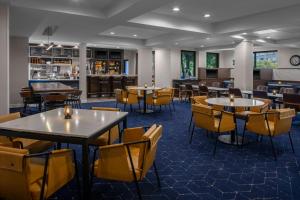 a restaurant with tables and chairs and a bar at Courtyard by Marriott Richmond Northwest in Henrico