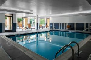 a swimming pool with blue water in a building at Courtyard by Marriott Richmond Northwest in Henrico